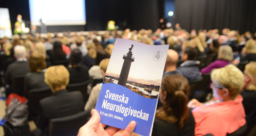 Ett programblad framför en stor publik