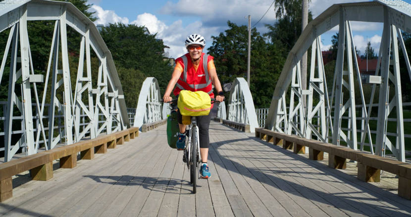 Jenny Ljungberg cyklar på en landsväg. Foto.