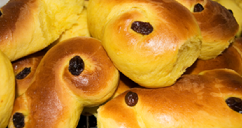 Saffransgula lussekatter med russin i närbild. Foto.