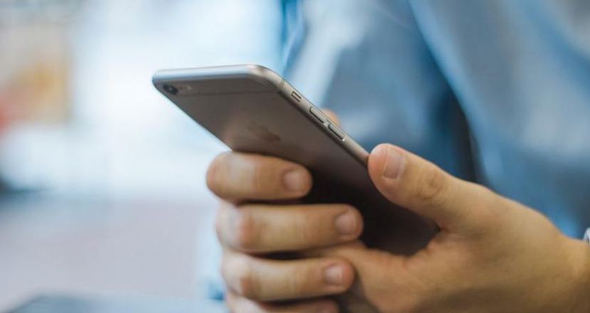 Man som håller i mobil