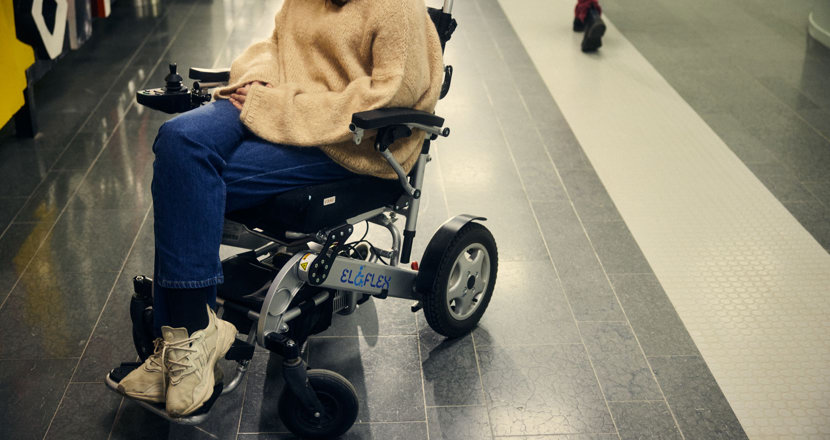 Person som sitter i en rullstol där ansiktet inte syns. Foto.