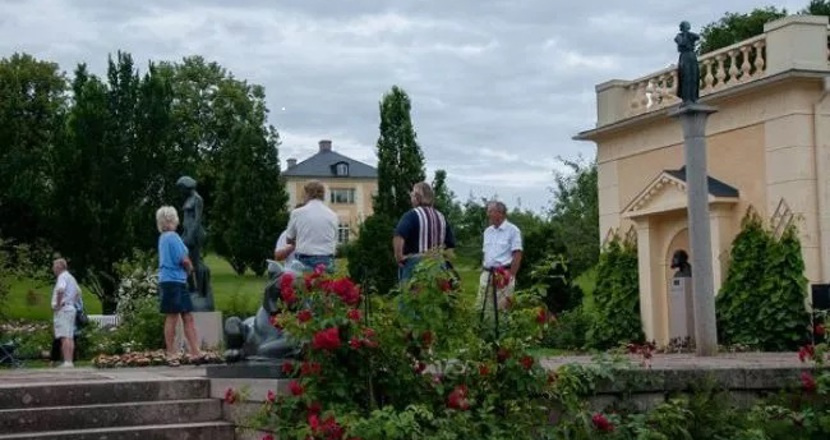 Några människor som strosar i en park. Foto.