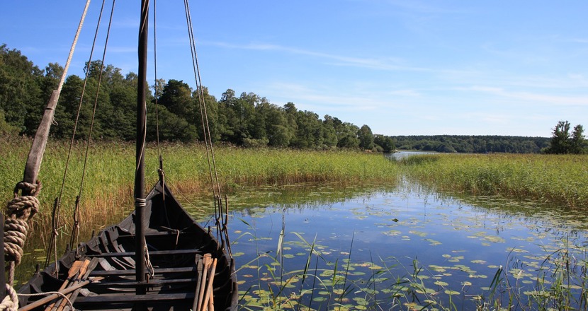 Fören av en vikingabåt i vacker grön natur.