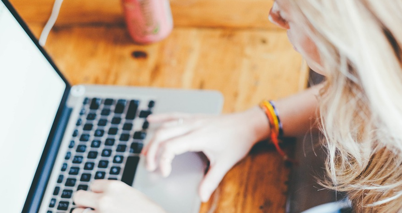 Tjej som sitter vid pc med långt ljust hår