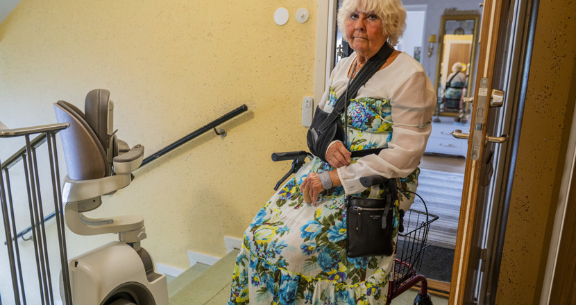 Annelie sitter på sin rullator med ena armen i en mitella. Foto.