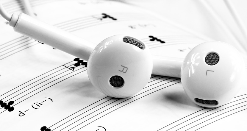 Bild på små hörlurar och noter
