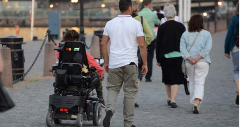 Foto på person med assistent på promenad