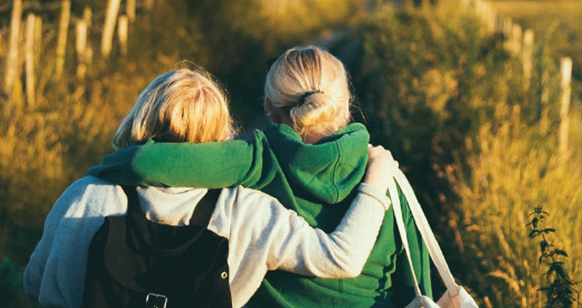 Två tjejer som stöttar varandra på promenad.
