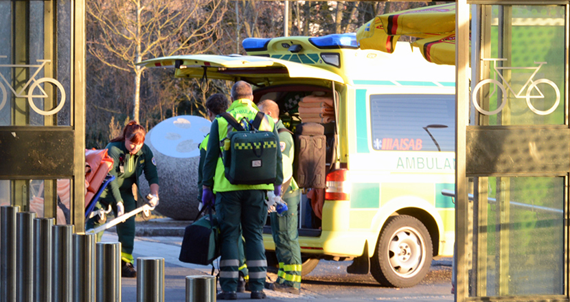 Personal som lastar en tom brits i en ambulans. Foto.