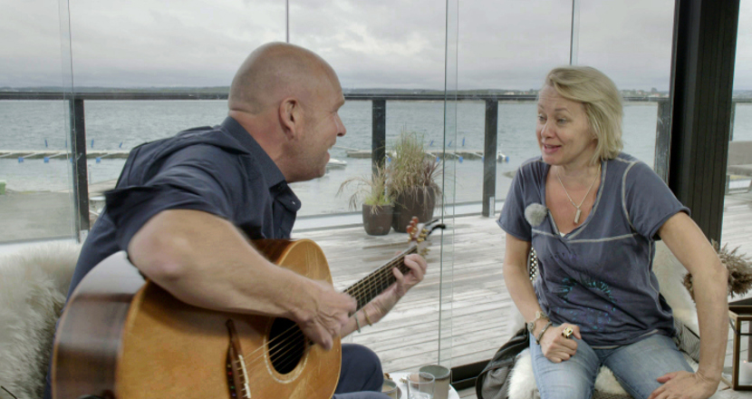 Lasse Kronér och Louise Hoffsten på en veranda vid havet.