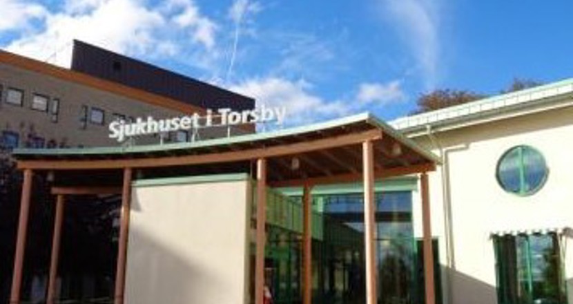 Entrén till sjukhuset i Torsby med en blå himmel. Foto.