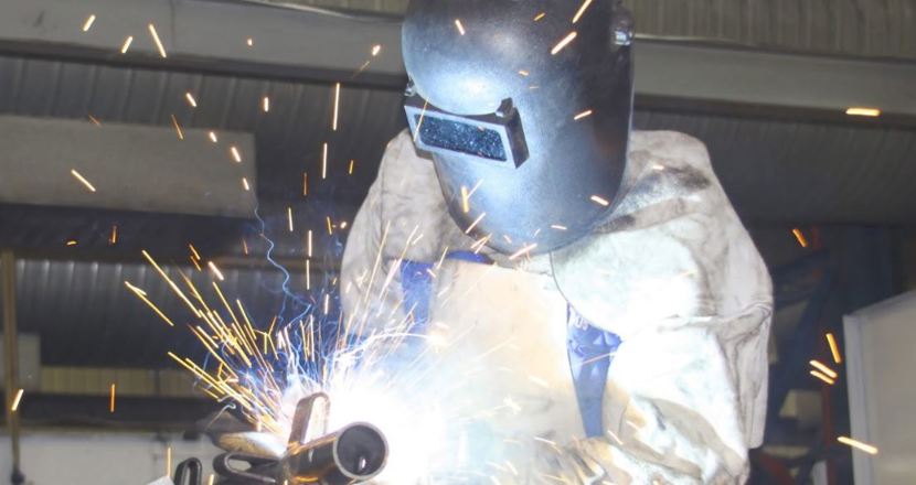 person i skyddsutrustning som svetsar