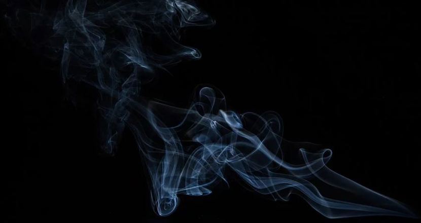 ljus rök mot svart botten