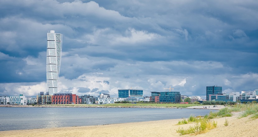Strandbild med Turning torso i bakgrunden. Foto.