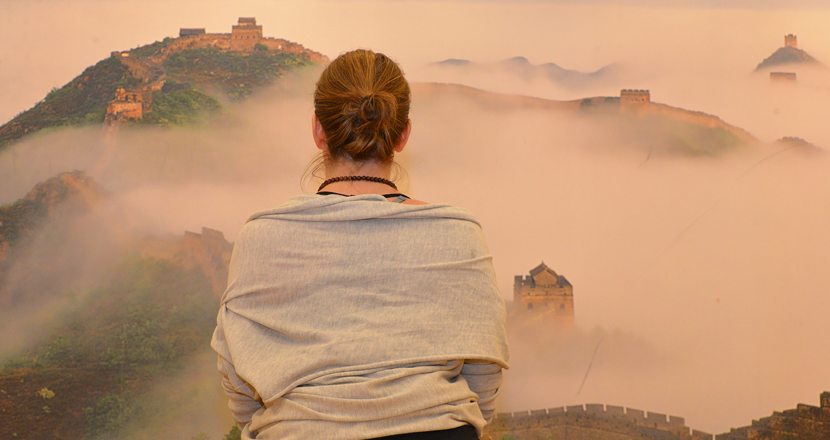 En kvinna i yogaposition, sedd bakifrån. Foto.