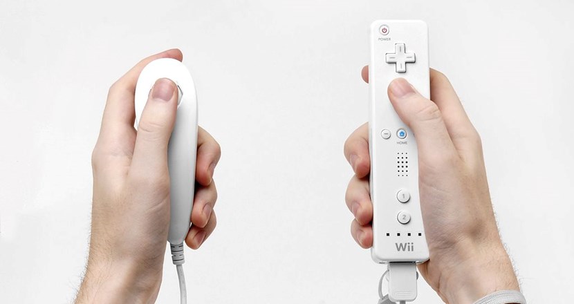 Två händer med en tv-spelkontroll i vardera hand, Nintendo Wii. Foto. 