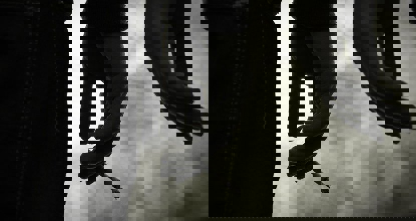 Svartvitt foto med två händer. En hand håller i en cigarett.