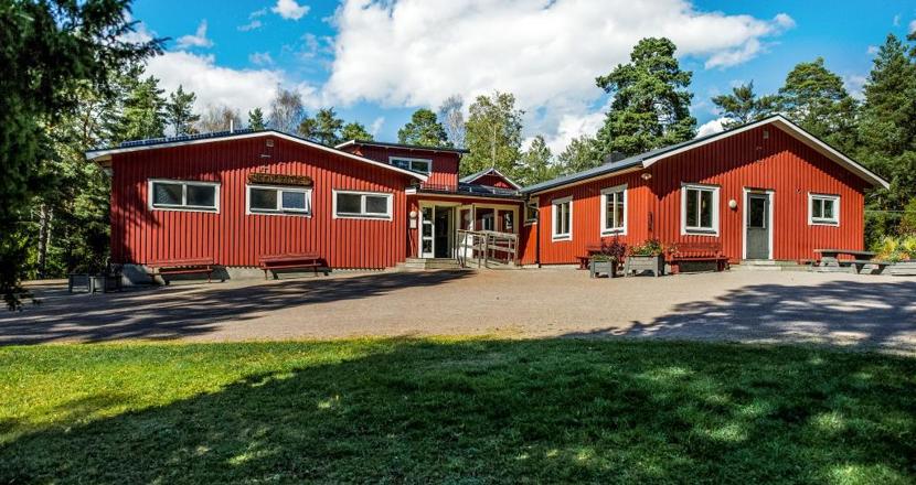 En bild på Kilenegården, ett falurött hus med en ramp vid ingången i mitten av huskropparna. Foto.