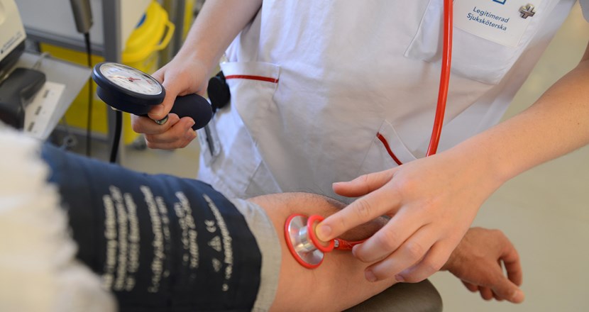 Sjuksköterska som tar blodtryck på en patient. Foto.