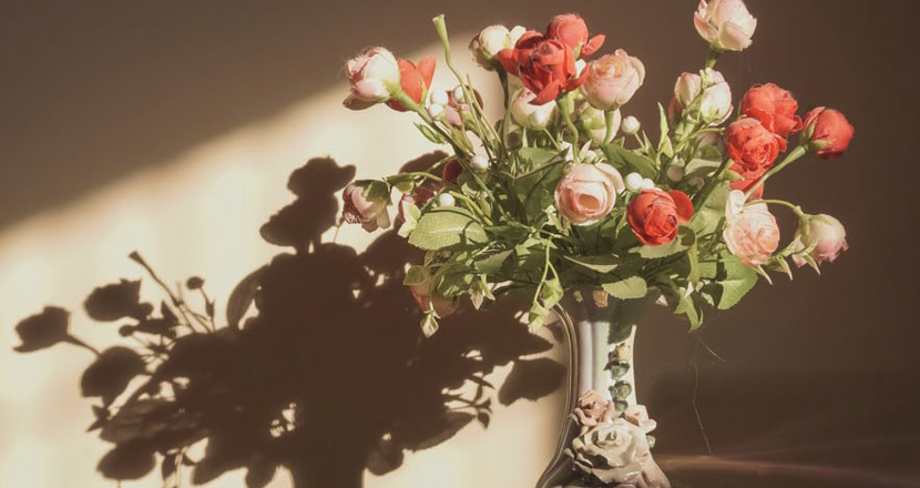 En blombukett i ett mörkt rum. Foto.