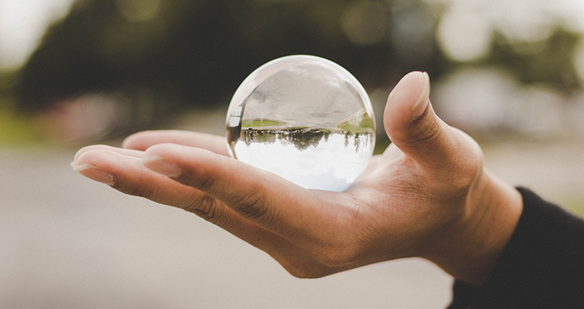 Utsträckt hand med kristallkula. Fotografi. 