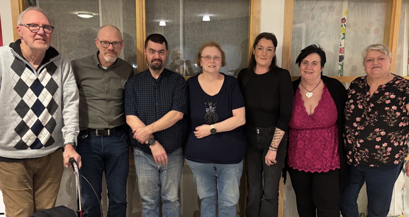 Personer runt ett bort men papper och dator